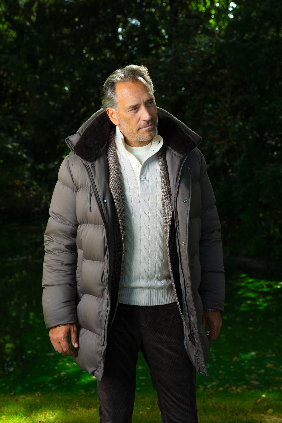 Look HW26/27 – Taupe lange donsparka met bontkraag en crème kabeltrui | Gentlemen Mode